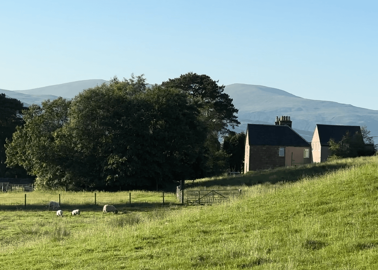 Scottish countryside, a stone cottage in the hills below the mountains